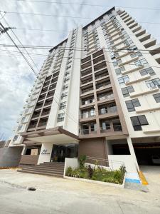 Un gran edificio de apartamentos blanco con escaleras al frente. en Spacious Condo Studio Unit in Mactan Cebu, en Lapu Lapu City
