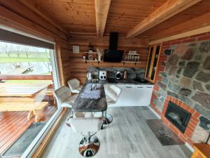 a kitchen with a stone fireplace in a log cabin at Atokvėpis Alantos kaime in Alanta