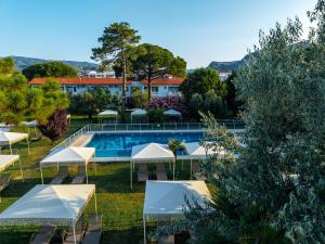 ein Resort mit Swimmingpool und Sonnenschirmen in der Unterkunft Palm Beach Hotel in Küçükkuyu