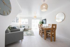 a living room with a table and a couch and a clock at Stylish 3 or 4 Bed House and Parking in Manchester