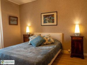 a bedroom with a bed with two lamps on it at Gite de Conquettes in Canet-de-Salars