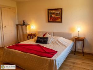 a bedroom with a bed with a red blanket on it at Gite de Conquettes in Canet-de-Salars