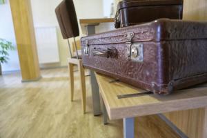 a brown suitcase sitting on top of a wooden table at Landgasthof zum Hirschen in Sulzfeld (im Grabfeld)