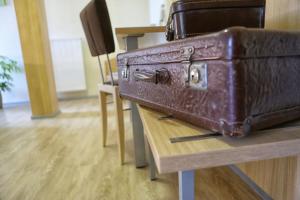 una maleta marrón sobre una mesa de madera en Landgasthof zum Hirschen, en Sulzfeld