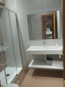 a white bathroom with a sink and a mirror at Villajoyosa Arsenal in Villajoyosa +18 photos