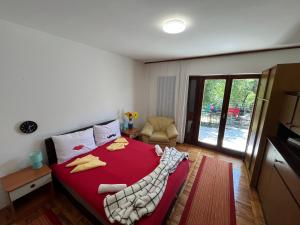 - une chambre avec un grand lit rouge et une couverture rouge dans l'établissement Apartman Ramiza, à Jadranovo