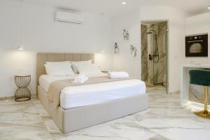 a white bedroom with a bed and a shower at ΔVO luxury apartment in Agios Nikolaos +16 photos
