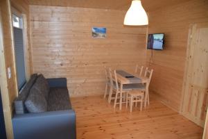 a living room with a table and a couch at Domki u Ani Rusinowo in Rusinowo
