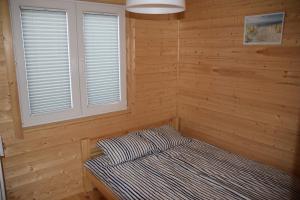 a sauna with a bed in a wooden room at Domki u Ani Rusinowo in Rusinowo