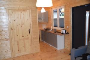 a kitchen with a wooden door in a room at Domki u Ani Rusinowo in Rusinowo +20 photos
