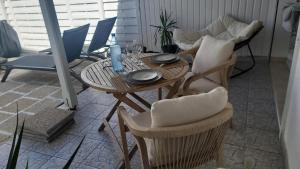 a table and chairs in a living room at Le Maracuja Parenthèse tropicale & jacuzzi privé in Sainte-Anne