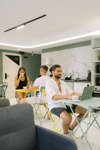 a group of people sitting at tables with a laptop at U-nit Hostel Central Park in Valencia +49 photos