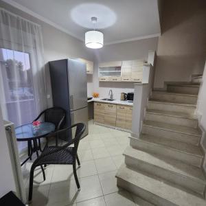 a kitchen with a staircase and a table and a refrigerator at Potamos Townhouse & Shared Garden in Potamós