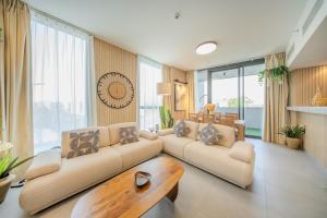 a living room with two couches and a table at 2BR Aljada Apartment - Forest Themed - Sleeps 6 - Balcony in Sharjah