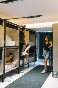 a group of people standing in a room with bunk beds at U-nit Hostel Central Park in Valencia