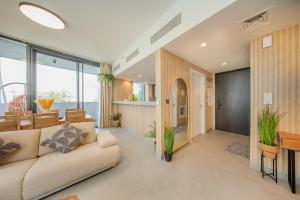 a living room with a couch and a table at 2BR Aljada Apartment - Forest Themed - Sleeps 6 - Balcony in Sharjah