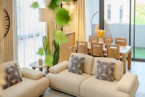 a living room with a couch and a table at 2BR Aljada Apartment - Forest Themed - Sleeps 6 - Balcony in Sharjah +41 photos