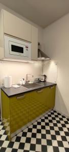 a kitchen with a sink and a microwave at Chessboard apartment in old town Riga, Coffee included in Rīga