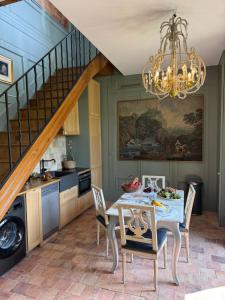 a kitchen and dining room with a table and a chandelier at L'appartement Montmorency in Saint-Paterne-Racan +18 photos