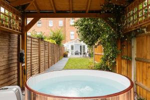 a hot tub in a backyard with a fence at Mallside Meadows - Hot Tub, Games Room, Garden in New Southgate