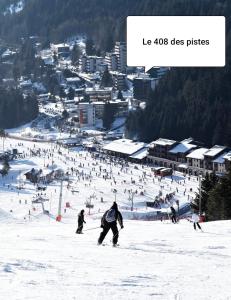 a group of people skiing down a ski slope at Le 408 des pistes in La Bresse