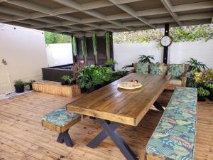 a wooden table and chairs on a patio at Cowes Cottage in Fish hoek