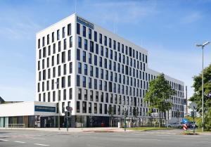 a tall white office building with a lot of windows at Four Points Flex by Sheraton Essen in Essen