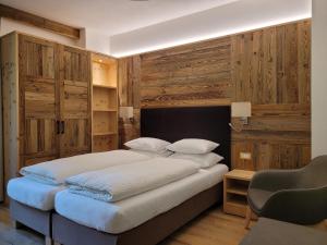 a bedroom with a large bed with wooden walls at Hotel Garni Royal in Arabba