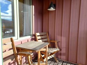einen Holztisch und Stühle auf einer Veranda mit einem Fenster in der Unterkunft AGO Nya Lundsgården in Åre