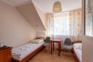 a bedroom with a bed and a table and chairs at Baltic Apartment Rewal - Bartek in Rewal
