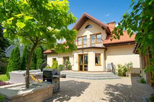 ein Haus mit einem Baum davor in der Unterkunft Willa pod Warszawą Perfekcyjna na Eventy i Spotkania Firmowe in Kobyłka