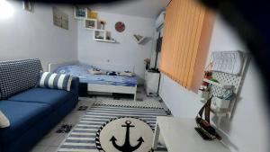 a small room with a bed and a blue couch at Studio Olimp Black Sea in Olimp