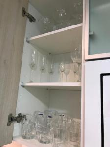 a bunch of wine glasses in a cabinet at Lovely modern two bedroom apartment in Arenales del Sol