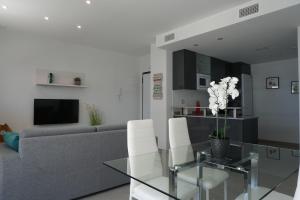 a living room with a couch and a glass table at Lovely modern two bedroom apartment in Arenales del Sol