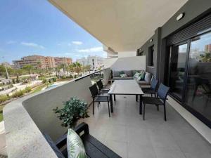 a patio with a table and chairs on a balcony at Lovely modern two bedroom apartment in Arenales del Sol