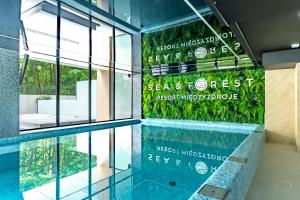 einen Pool in einem Gebäude mit einem Schild an der Wand in der Unterkunft Sea & Forest Resort Międzyzdroje in Misdroy