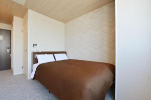 a bedroom with a large bed in a room at Hotel New Gaea Domemae in Fukuoka