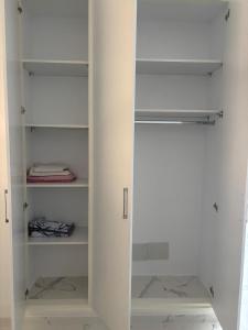 a white walk in closet with a door open at Résidence Molka Yasmine Hammamet in Hammamet
