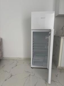 a white refrigerator with its door open in a kitchen at Appartement 1 Yasmine hammamet in Hammamet