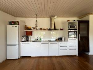 a kitchen with white cabinets and a white refrigerator at Koidu Apartment Kuressaare in Kuressaare