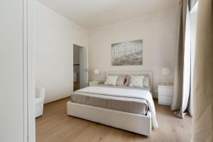 a white bedroom with a bed and a painting on the wall at Villa Adele by Perle di Puglia in Maruggio +43 photos