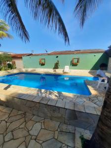 einen Pool im Garten mit Palmen in der Unterkunft Área de Lazer Sertãozinho in Sertãozinho