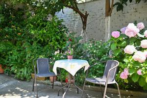 a table with two chairs and a table with flowers at SEN Garden Home in Tirana