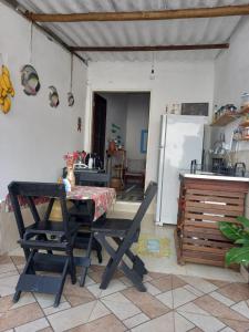 a kitchen with a table and a refrigerator at Casa caiçara Paraty in Paraty