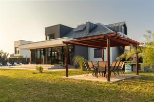 Una casa con una mesa y sillas delante de ella. en Villa Una Residence, en Bihać