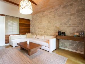 a living room with a white couch and a stone wall at Kimera Lounge Hotel in Cıralı