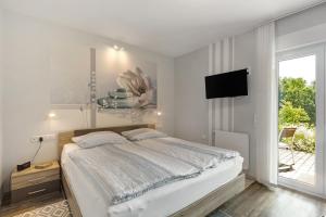 a bedroom with a bed and a flat screen tv at Ferienwohnung Sonnenblick in Bad Berleburg