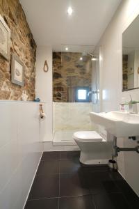 a bathroom with a sink and a toilet and a shower at Preciosa casa en Playa de Razo in Carballo +38 photos