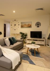 迪拜Goodwill Holidays ,Near Jumeirah Beach Residence 1的带沙发、电视和桌子的客厅