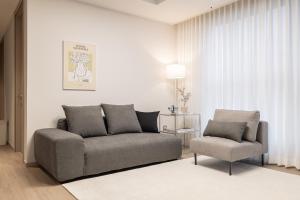 a living room with a couch and a chair at Stylish Modern Condo, 3 Bedrooms, 2 Bathrooms, 4 Air Conditioners, 65-inch TV, Laundry Machine & Dryer in Seoul